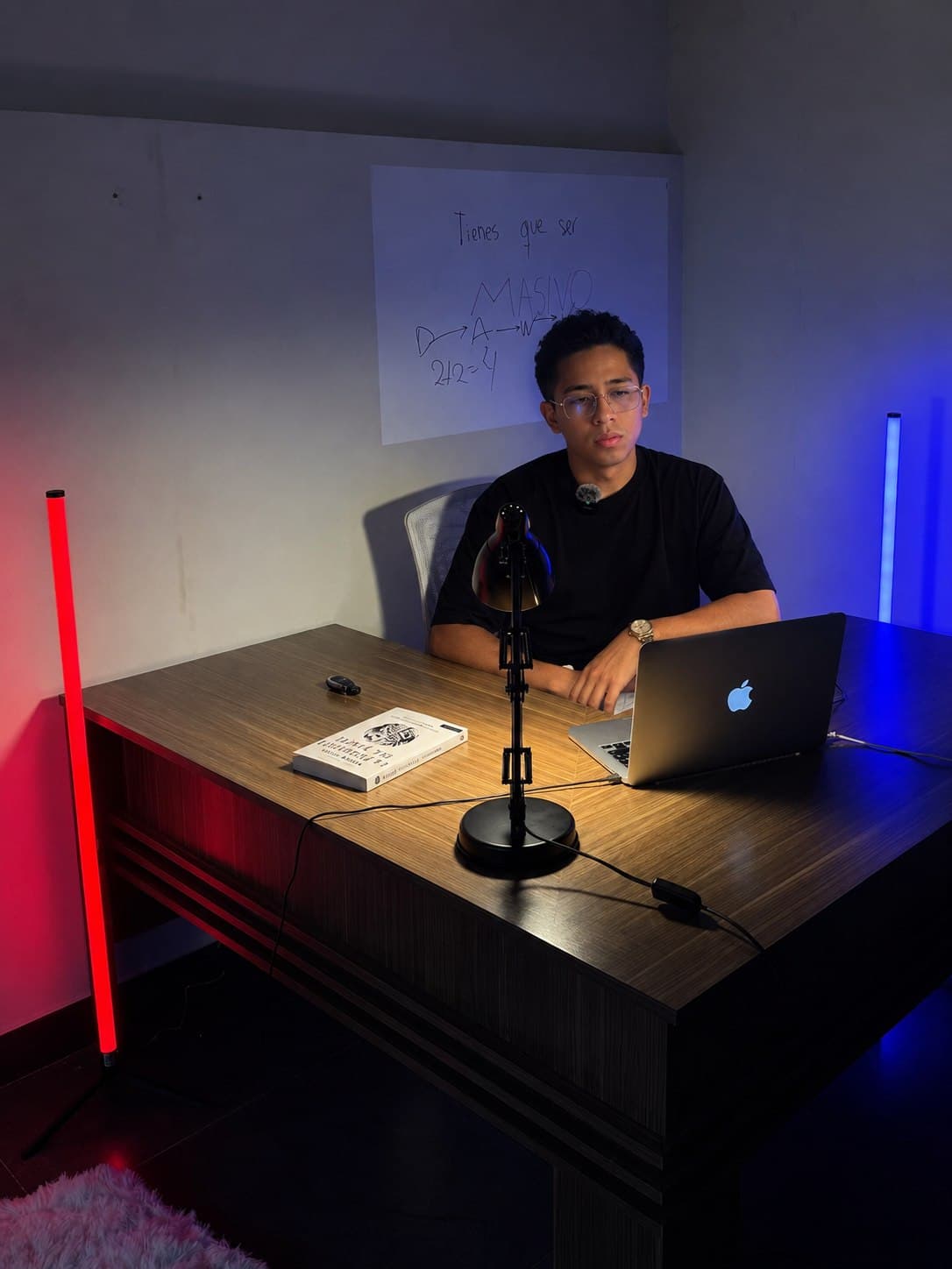 Jeremy Baldarrago en su estudio, frente al portátil y con la pizarra de trabajo detrás